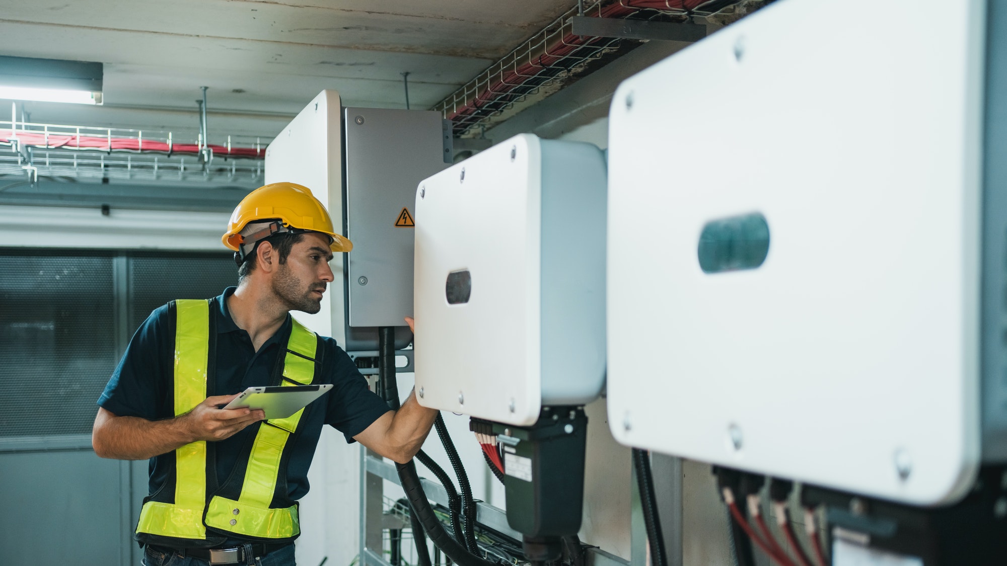 Technician Engineering setting inverter solar panel in electrical room.